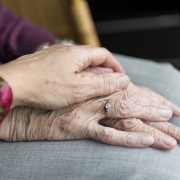 jonge hand ligt op oude hand